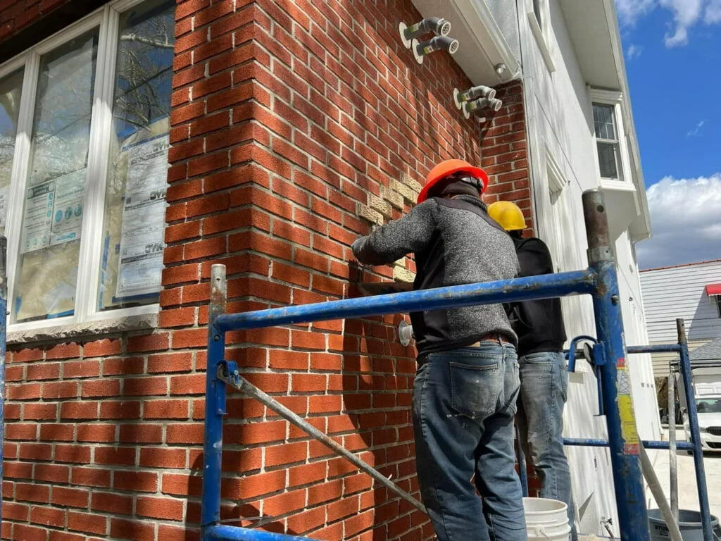 Louise August masons repointing brick on a Washington DC home